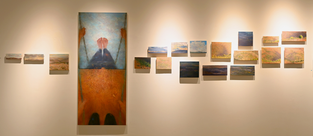 Eighteen small landscape paintings on the gallery wall, with the large painting Swing 1 among them נד נד.